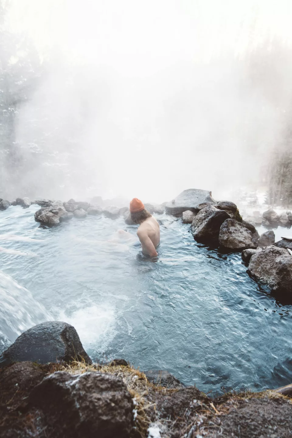 Personne assise dans une eau fumante, enveloppée de brume
