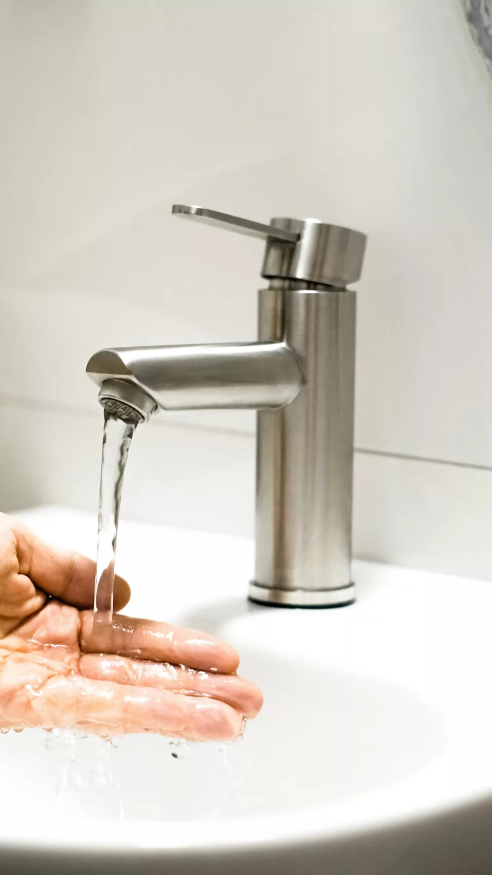 Mains se lavant sous un filet d'eau au robinet